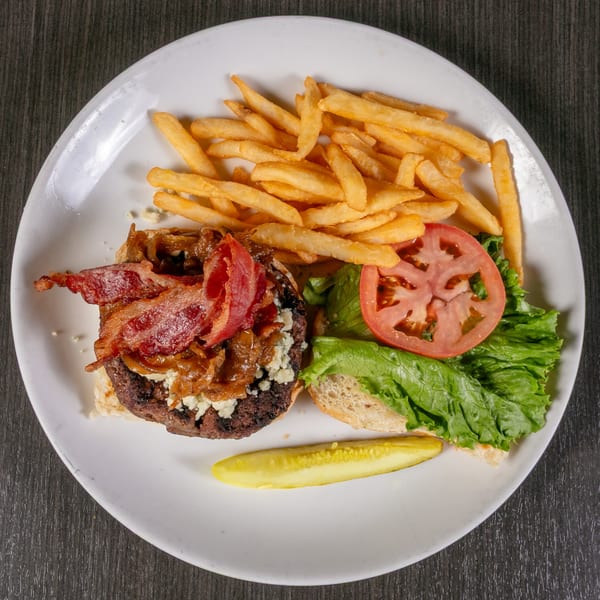 A Post Office Pub burger with bacon, caramelized onions, blue cheese, fries, and a pickle.