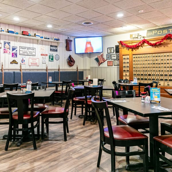 Interior of Post Office Pub Restaurant with tables, chairs, and post office themed decor.