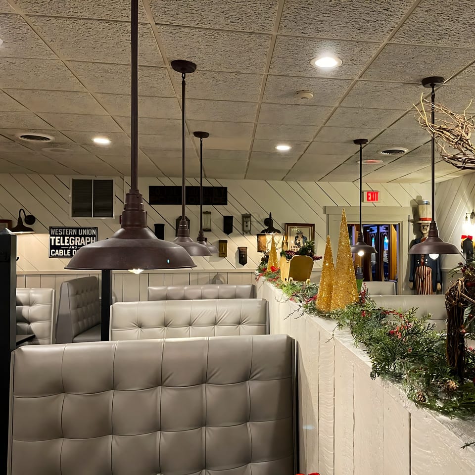 Cozy dining area at Post Office Pub with booth seating, industrial lighting, and festive decorations.